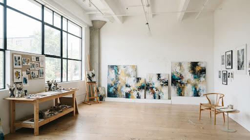 Bright, minimalist art studio with large canvases leaning against white walls