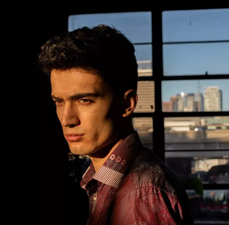 Portrait of artist Jake Bailey lit by warm window light